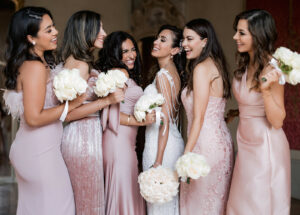 bridesmaids and bride with a pink dress and flower